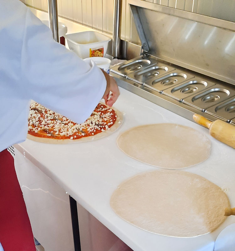 Un pizzaïolo en train de préparer une pizza.